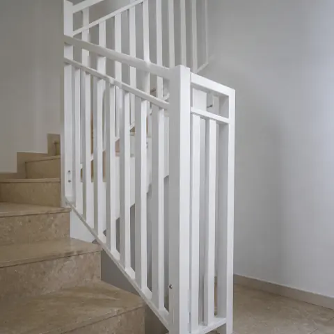 Weisses Metallgeländer an Marmortreppe