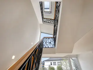 Blick die Treppe hinauf über drei Geschosse mit durchgehendem Geländer