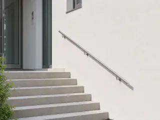 Der gleiche Edelstahl-Handlauf am Hauseingang über Natursteinstufen