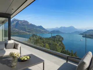 Blick von der Terrasse aus mit Sitzmöbeln neben der Glasbrüstung