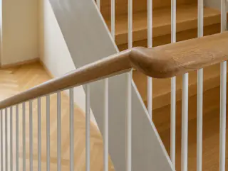 Nahaufnahme des Eichenhandlaufs auf dem weissen Stahlgeländer