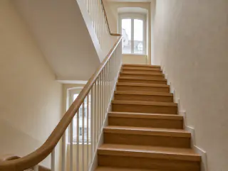 Blick von unten die Treppe hinauf entlang des weissen Geländers