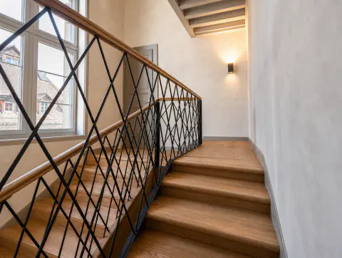 Blick von unten die Treppe hinauf entlang des Geländers